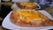 Adjarian Khachapuri on a Table in a Georgian Restaurant. Open bread pie with egg yolk