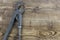 Adjustable gray vintage gas pipe wrench lays on wooden background.