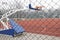 Adjustable and portable basketball stand hoop in outdoor sports yard, behind the wire fence