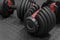 Adjustable weight dumbbell in plastic polymer material on black rubber