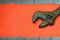 Adjustable wrench against the background of an orange signal worker shirt. Still life associated with repair, railway or plumbing