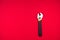 Adjustable wrench with black rubberized handle, on red background.Top view. Space for text