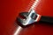 The adjustable wrench lies on the red polished surface in the auto repair shop. Devices for work of the mechanic and the joiner