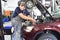 Adjusting the headlights on the car by mechanics in a garage