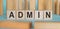 Admin word made from wooden blocks on blue table