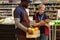 Administrator of supermarket making notes while standing by sales assistant