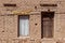 An adobe brick wall with a window and a door