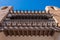 Adobe building with balcony and carved beams.