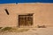 Adobe building with old door and bench