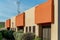 Adobe orange and beige stucco business building with radio communication tower and front yard shrubs and plants