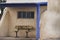 Adobe shelter with bench, windows and blue trim at campground