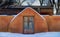 Adobe Wall and Wooden Door in the Snow