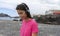 Adolescent Girl listening a song in pier, relaxed and smiling ready to training close to the sea. Young lady listen the radio with