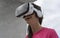 Adolescent interacting with innovative tech virtual reality glasses smiling and playing, touching a dream. Lady reaching visual