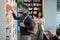 Adolescent man in casualwear taking book from bookshelf