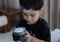 Adorable 3 to 4 year olds Asian boy standing with flashlight in hands and play switch on and off with fun and curiosity
