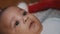 Adorable african american black baby boy lying on the towel. Christmas hat in the background