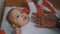 Adorable african american black baby playing with fathers hand while lying on the blanket surrounded with presents