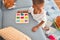 Adorable african american toddler learning maths using mathematics game around lots of toys at kindergarten