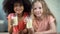 Adorable African and Caucasian girls holding glasses of milk, healthy eating