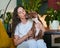 Adorable american pit bull puppy kissing pet parent while sitting on her knees in living room