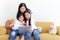 Adorable Asia happy family, cute two daughter girls with mother hold digital tablet, look and give red heart to web camera on