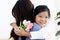 Adorable Asia happy smiling daughter girl giving beautiful tulip flowers for her mother and hugging her mom with love, warm love