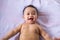 Adorable asian baby boy lying down on bed,Happy and smiling,Childhood and baby care concept