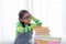 Adorable Asian girl pay attention looking to stack of books, elementary school girl worry to reading book or get headache, kid in