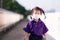Adorable Asian girl wearing a white cloth mask. Baby student was walking across the overpass to go to school in the morning.