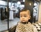 Adorable baby boy having a haircut at the barbershop