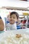 Adorable baby boy having rice for his lunch at a local restaurant