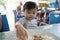 Adorable baby boy having rice for his lunch at a local restaurant