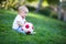 Adorable baby boy holding a red and white soccer ball