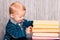 Adorable baby boy with a pile of books