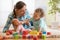 Adorable baby boy playing with doll in nursery. Happy healthy child having fun with colorful different toys at home.