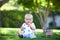 Adorable baby boy sitting on a lawn with American flag