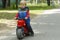 Adorable Baby Boy Sitting On A toy Motorcycle in the park. copy space