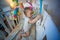 Adorable baby boy standing in crib and playing with toy carousel