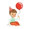 Adorable baby boy wearing a red party hat sitting and holding red balloon. Kids birthday party colorful cartoon