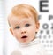 Adorable baby child with eyesight testing board