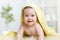 Adorable baby child under bathing towel indoor