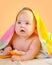 Adorable baby in colorful towel after bath