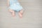Adorable baby crawls on a wooden parquet.
