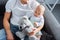 adorable baby daughter playing with teddy bear while sitting with father on couch