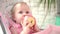 Adorable baby eating apple. Healthy nutrition fro kids. Cute baby gnawing apple