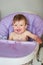 Adorable baby eating on baby chair and making a mess.