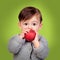 Adorable baby eating a red apple