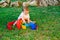 Adorable baby entertaining ordering a colorful rainbow toy sitting on the grass of a backyard