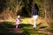 Adorable baby on forest path in nature.1 year old girl in woods with her mother